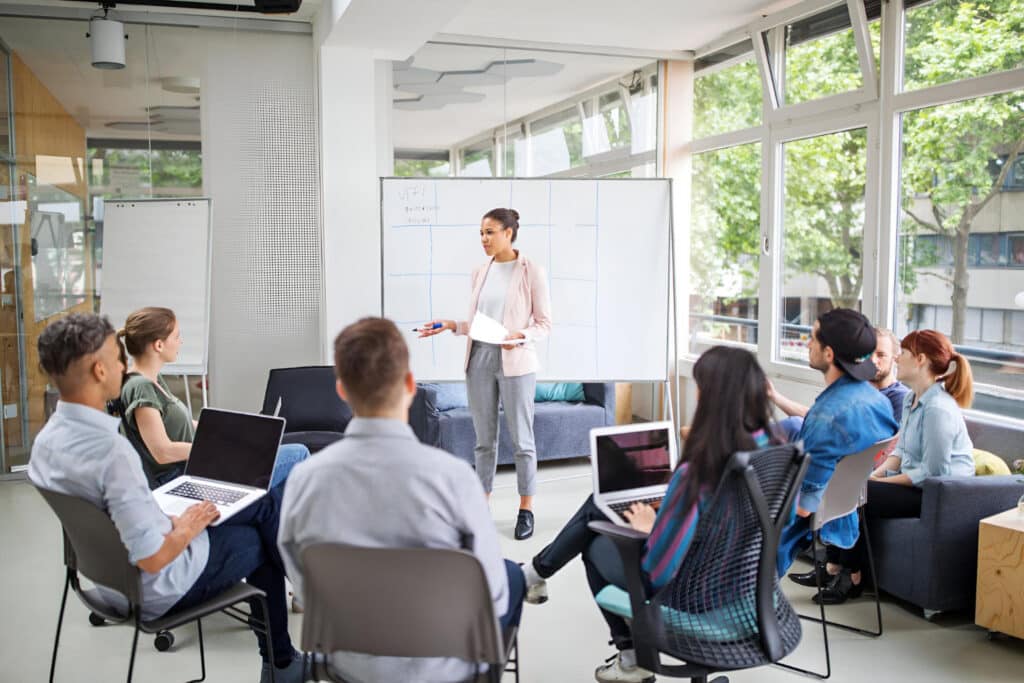 A female trainer delivers a session to a group of delegates.