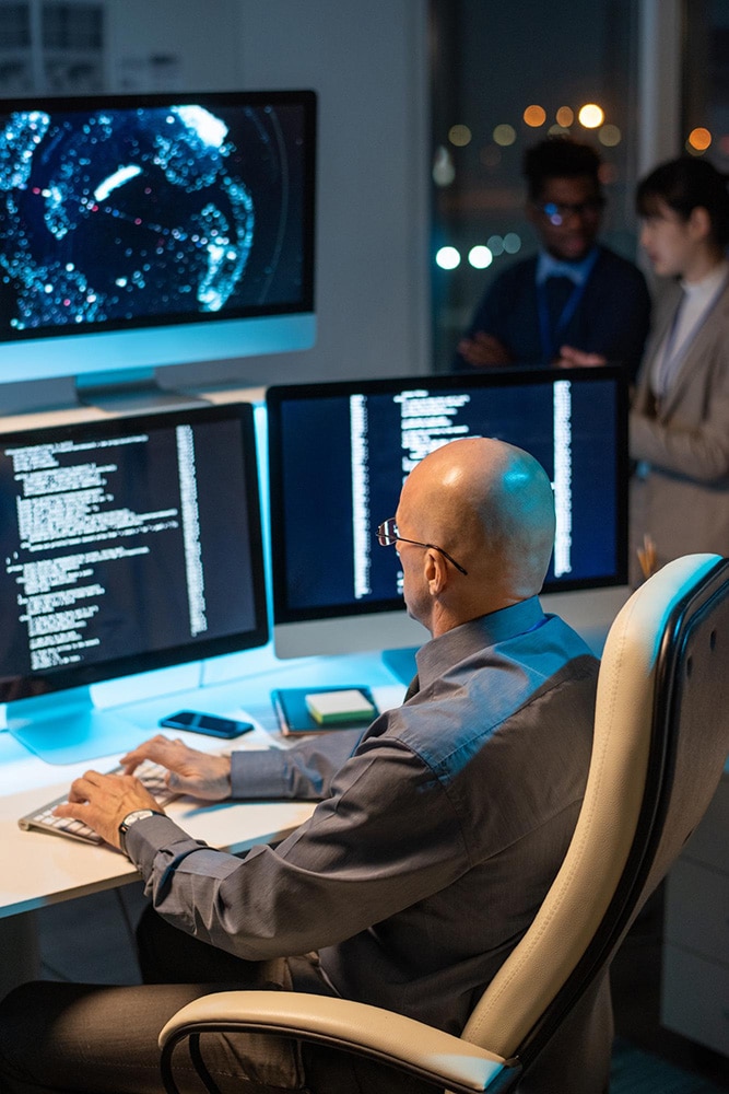A man writing code in a cyber security company