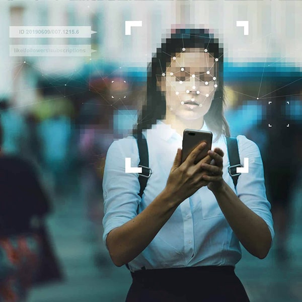A woman using a mobile phone with her face being read by digital identity security.